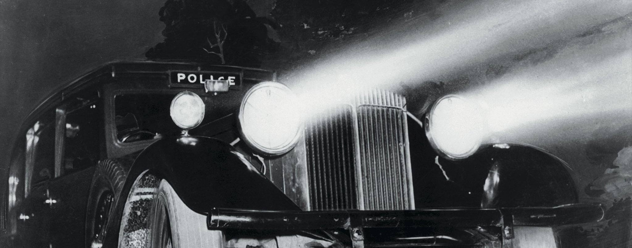 What's on Photo of early police car at nighttime